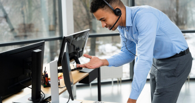 A focused man in a headset stands before a computer, representing immigration consultancy services in Chennai.